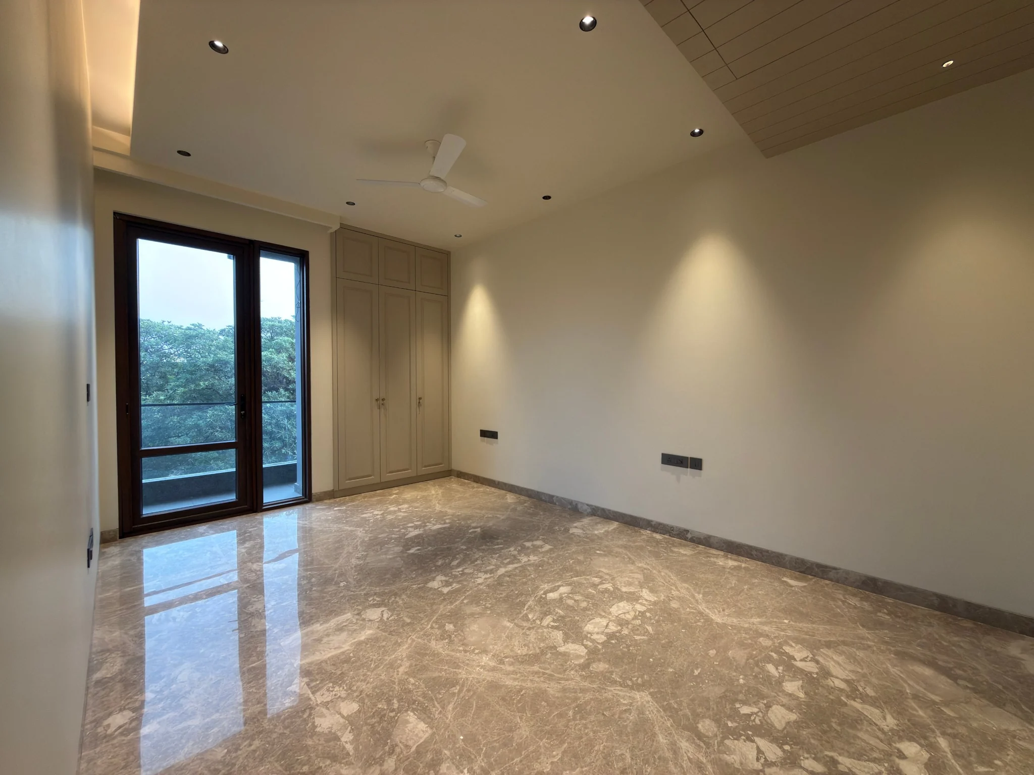 A bedroom, with a balcony door and a built-in wardrobe