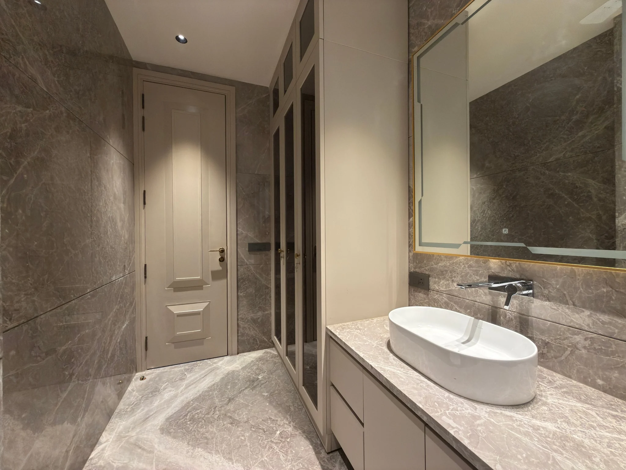 A dressing area with a basin and tall wardrobes