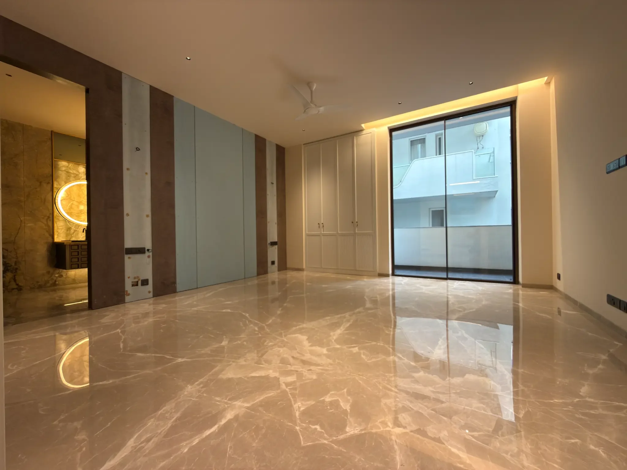 A bedroom, with built-in wardrobes and a full-height glass door