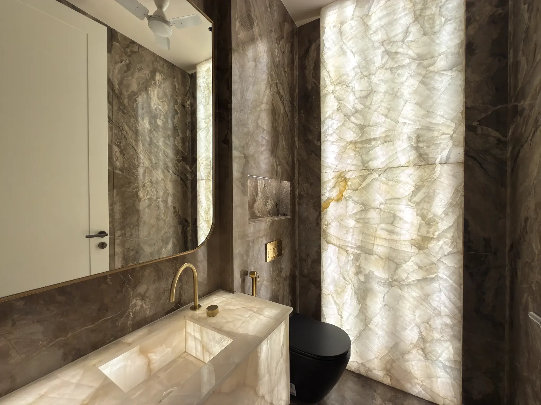 A washroom with a back-lit stone wall